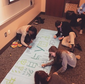 Students in the First Year Seminar class, Debunking the Myths of China, prepare the Chinese Environmental Film Festival banner.