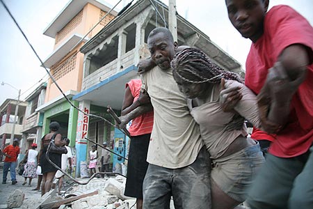 Woman being carried out of the rubble.