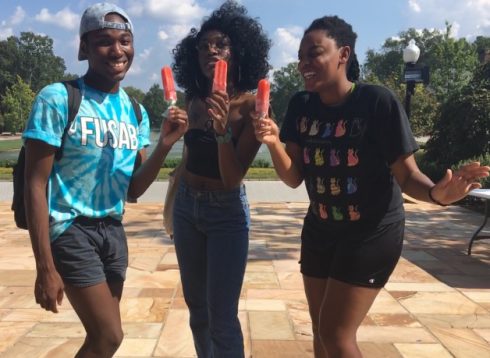 Three smiling African-American students with popsicles