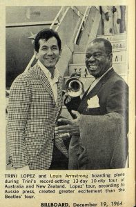 Louis Armstrong holding a trumpet in front of an airplane 